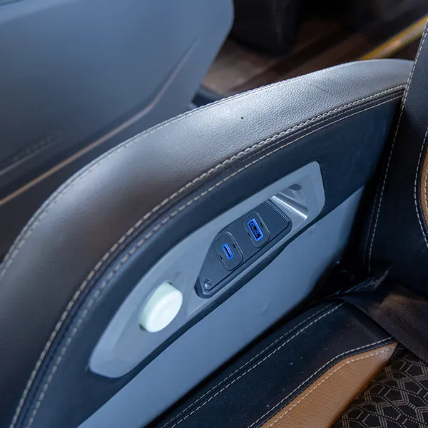 Detalhe de entradas USB na lateral de uma poltrona