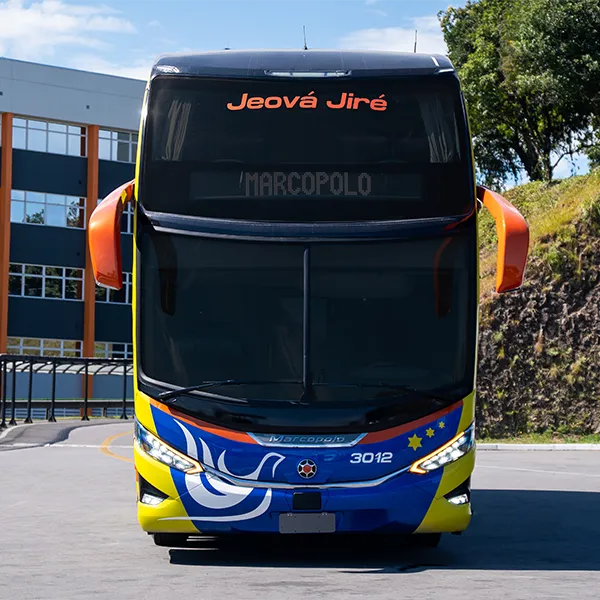 Frente do ônibus double deck da Shalom Turismo, com pintura amarela, azul e laranja e a pomba branca